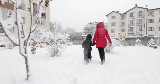 Щаслива родина мати і дочка розважаються, граючи на зимовій прогулянці — стокове відео