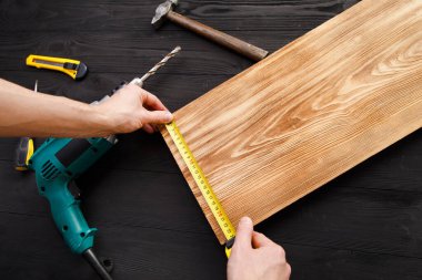 Mavi üniformalı tamirci otomatik tornavidayla çalışıyor..