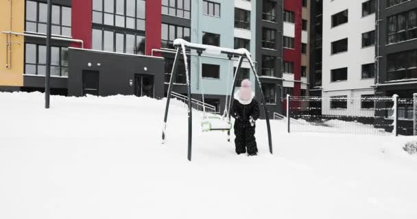 Barn leker med snö på lekplatsen — Stockvideo