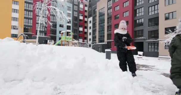 Niños juegan con nieve en el patio — Vídeos de Stock
