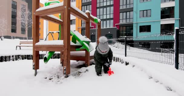 Bambini giocano con la neve nel parco giochi — Video Stock