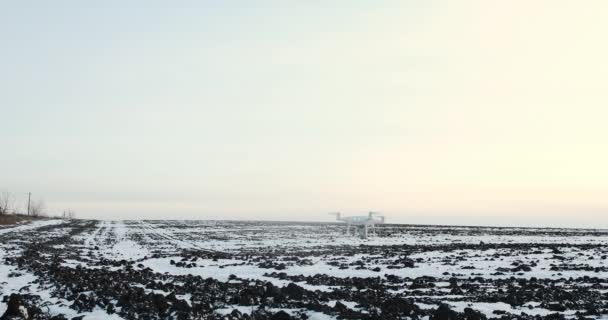 Drone terbang di atas lapangan tertutup salju pada hari musim dingin yang cerah — Stok Video