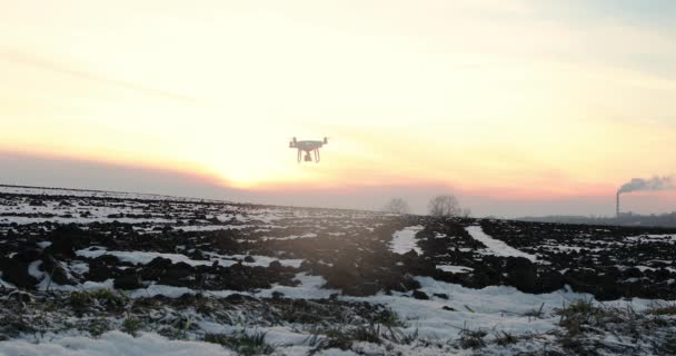 Беспилотник летит над полем, покрытым снегом, в солнечный зимний день — стоковое видео