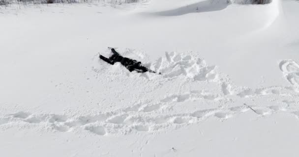 Feliz mulher de família e homem jaz na neve e faz um anjo — Vídeo de Stock