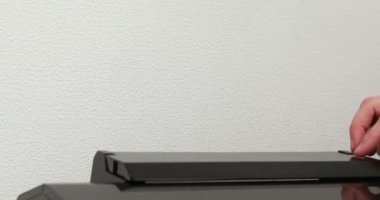 Ofis çalışanı kağıdı yazıcıya yüklüyor