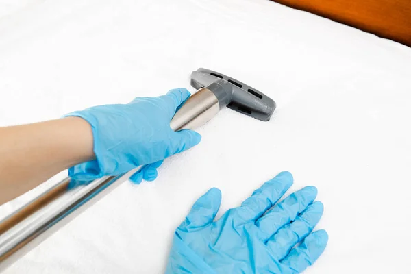 Janitor cleaning mattress with professional equipment in bedroom — Stock Photo, Image