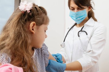 Çocuk aşısı. Hastanede bir çocuğu muayene eden doktor.