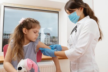 Çocuk aşısı. Hastanede bir çocuğu muayene eden doktor.