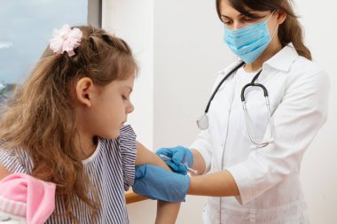 Çocuk aşısı. Hastanede bir çocuğu muayene eden doktor.