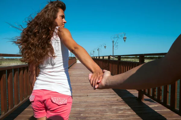Una chica va en un poste sosteniendo a un compañero en una mano — Foto de Stock