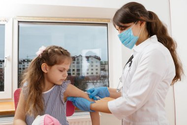 Çocuk aşısı. Hastanede bir çocuğu muayene eden doktor.