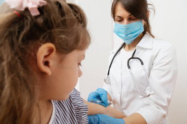 Çocuk aşısı. Hastanede bir çocuğu muayene eden doktor.