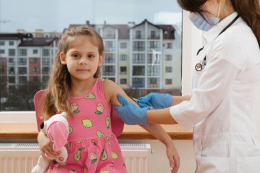 Çocuk aşısı. Hastanede bir çocuğu muayene eden doktor.