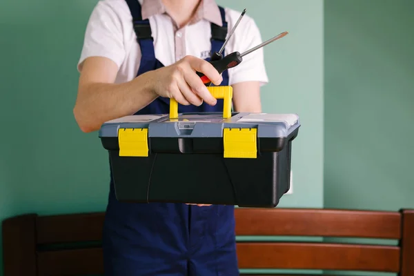 Un trabajador sostiene una caja de herramientas en su hombro. — Foto de Stock