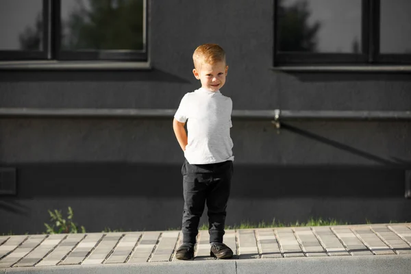 Un niño con una camiseta blanca. espacio para su logotipo o diseño. — Foto de Stock