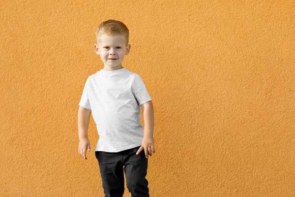 Um rapazinho de t-shirt branca. espaço para o seu logotipo ou design. — Fotografia de Stock