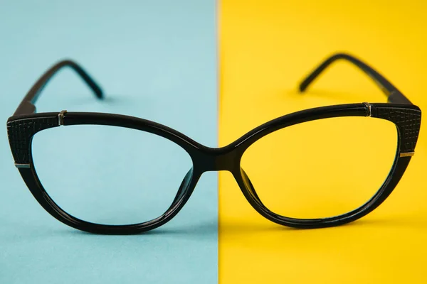 Gafas sobre fondo azul y amarillo. concepto de guerra en Ucrania —  Fotos de Stock