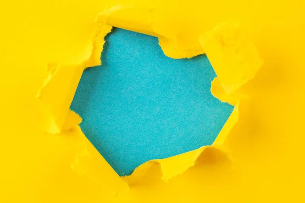 Foro giallo e blu nella carta con i lati strappati. — Foto Stock