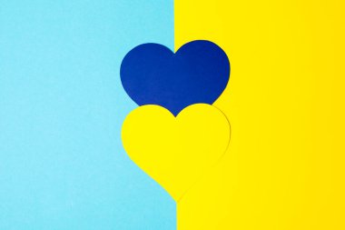 Savaş falan yok. Kadın ellerinde kağıttan yapılmış mavi ve sarı kalp. 