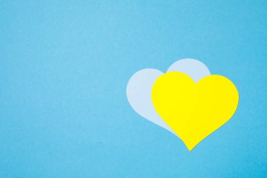 Savaş falan yok. Kadın ellerinde kağıttan yapılmış mavi ve sarı kalp. 