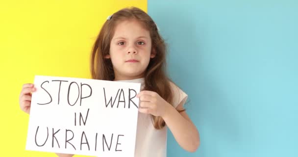 Bambina solleva banner con iscrizione fermare la guerra in Ucraina — Video Stock