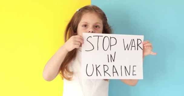 Gadis kecil menaikkan spanduk dengan tulisan menghentikan perang di Ukraina — Stok Video