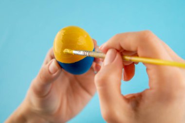 Ukrayna bayrağının rengini savaş konsepti olarak kadınlara veren paskalya yumurtası