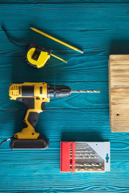 Mavi üniformalı tamirci otomatik tornavidayla çalışıyor..