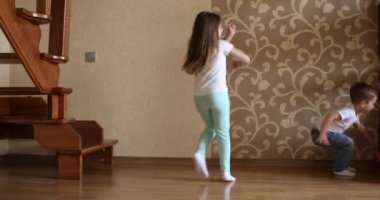 Kız ve oğlan evde top oynuyorlar.