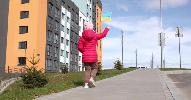 Porträt eines kleinen Mädchens mit der Fahne der Ukraine in der Hand. — Stockvideo