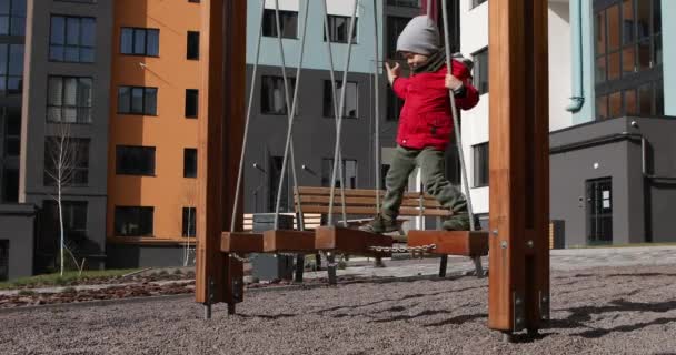 Der Junge läuft mit der Seilbahn. Kind spielt auf dem Spielplatz — Stockvideo