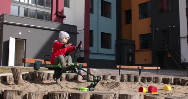 Boy playing in the sand on the playground — Stockvideo