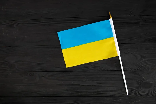 Bandera de Ucrania azul amarillo sobre fondo negro de madera — Foto de Stock
