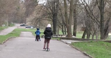 Sonbaharda parkta bisiklet süren bir çocuk.