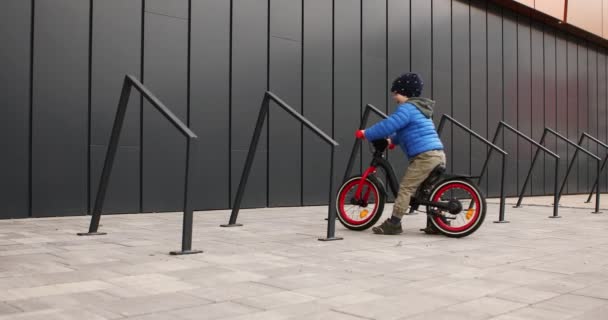 Little boy puts the bike in the parking lot — Stock Video