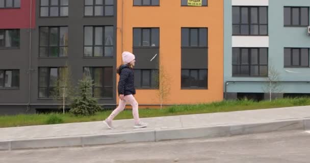 Piękna dziewczynka idąca ulicą — Wideo stockowe
