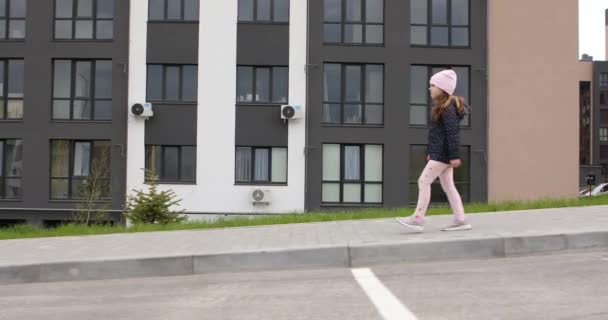 Beautiful little girl walking down the street — Stock Video