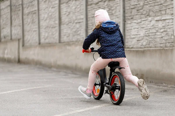 Little girl riding a bike in the yard — 스톡 사진