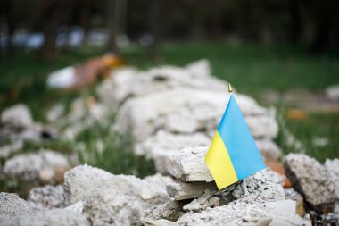 flag of ukraine against the background of a destroyed house