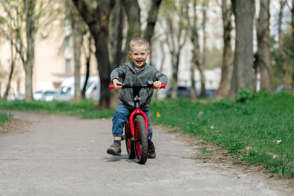 Chico montando una bicicleta en la calle. Aprender a montar en bicicleta concepto — Foto de Stock