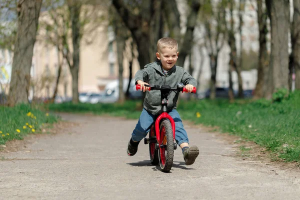 Chico montando una bicicleta en la calle. Aprender a montar en bicicleta concepto — Foto de Stock