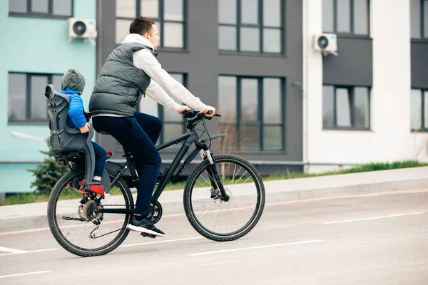 Padre montar en bicicleta con hijo en asiento de bicicleta — Foto de Stock