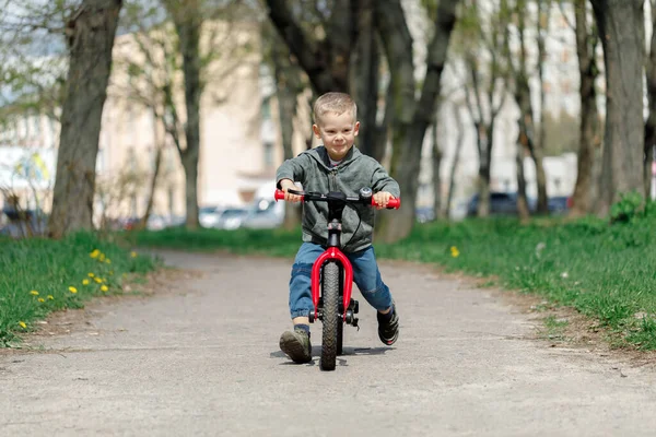 Chico montando una bicicleta en la calle. Aprender a montar en bicicleta concepto — Foto de Stock