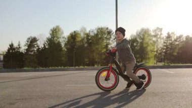 Yaz parkında bisiklet süren küçük bir çocuk. Dışarıda bisiklete binmek