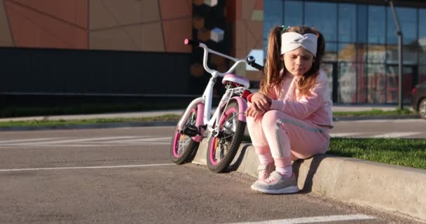 Little sad girl sitting on the curb — Stok video