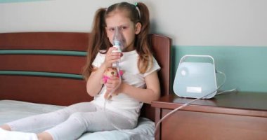 Kız evde nebulizörle solunum yapıyor..