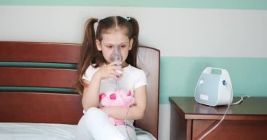 Kız evde nebulizörle solunum yapıyor..