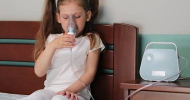 Kız evde nebulizörle solunum yapıyor..