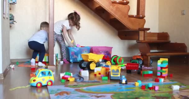 Дети убирают игрушки в детской комнате — стоковое видео