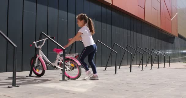 Klein meisje rijden een fiets in het park op een zonnige dag — Stockvideo